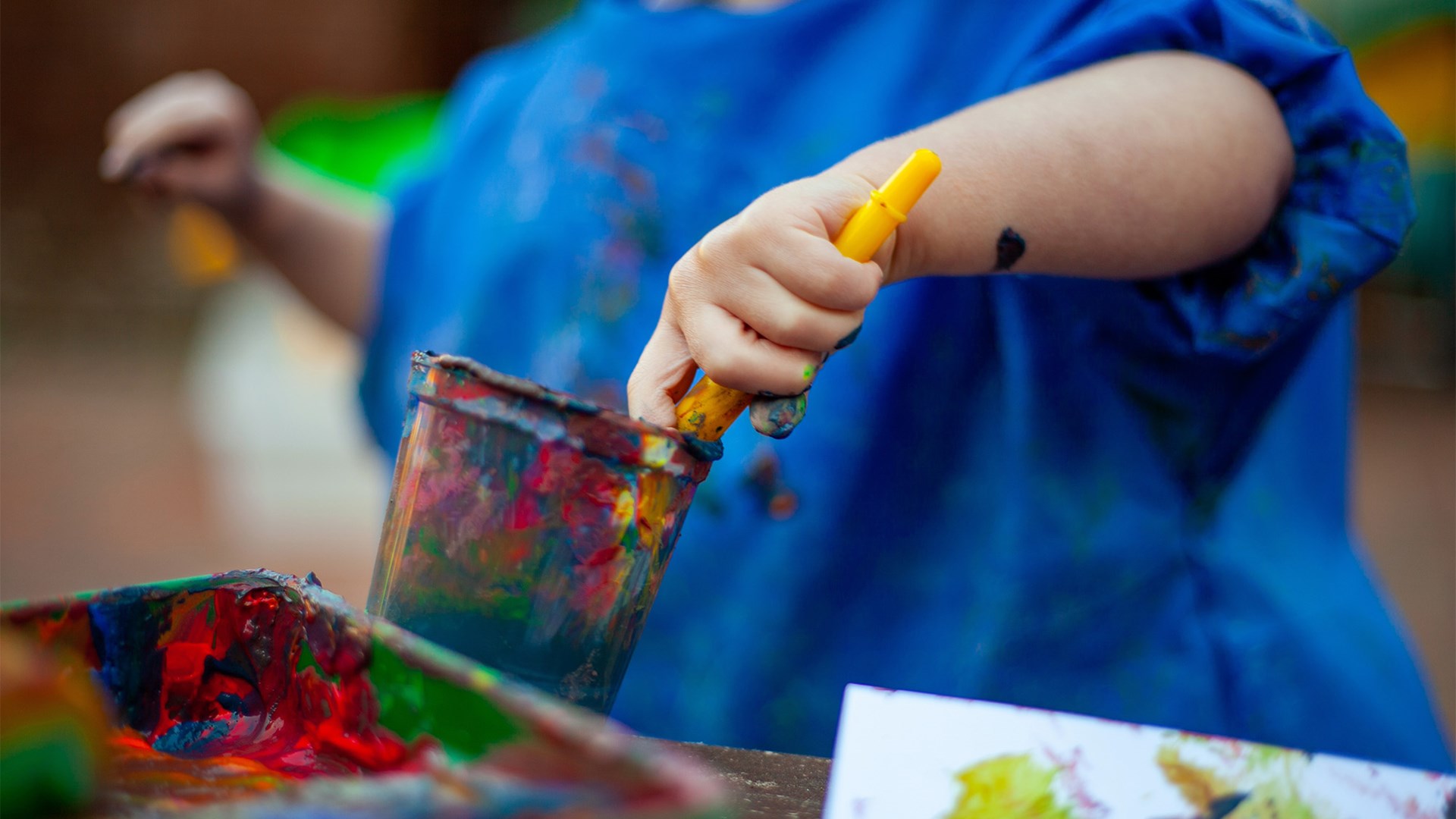 Young Child With Paint Brush In Pot